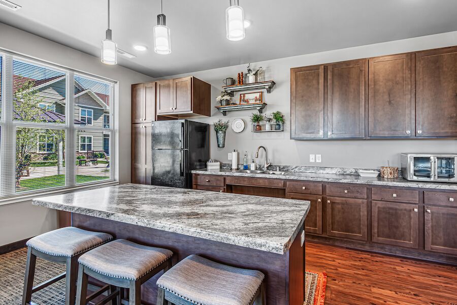 Community kitchen with large granite island and bar stools