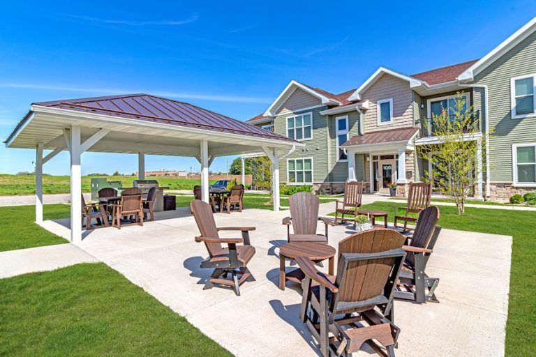 Covered outdoor pavilion with patio chairs in front of the building